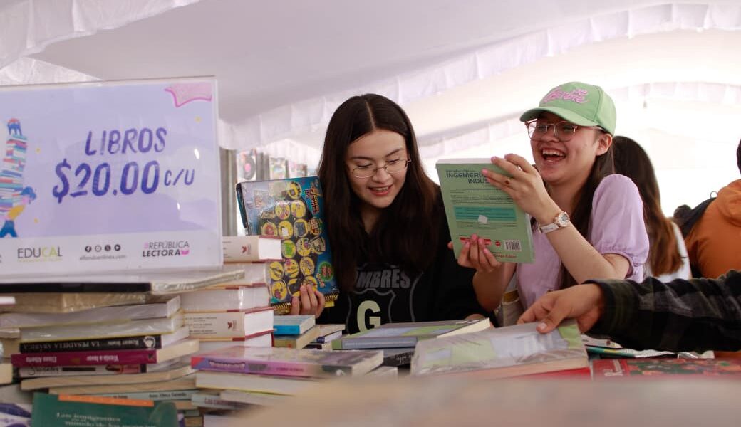 Jóvenes revisan libros durante el 22º Gran Remate de Libros, Discos y Películas en el Monumento a la Revolución